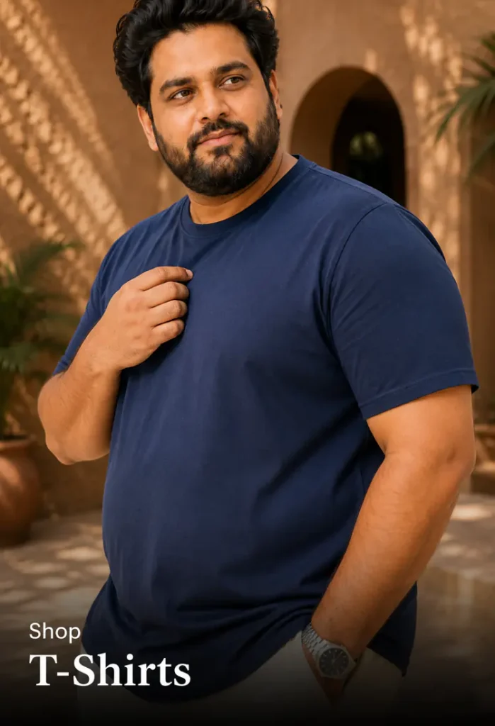 Plus size t-shirts Pakistan - man in navy crew neck t-shirt against a sunlit courtyard wall